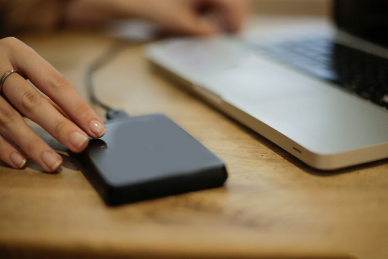 Black square external hard drive on brown wooden table